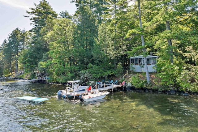 dock area with a wooded view and a water view