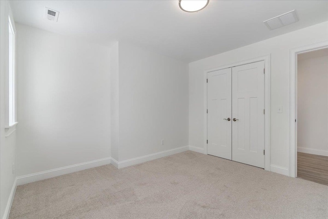 unfurnished bedroom with visible vents, a closet, baseboards, and carpet floors