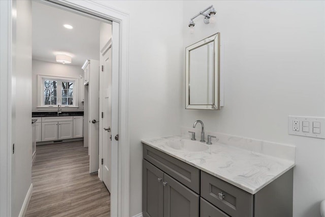 bathroom featuring baseboards, wood finished floors, and vanity