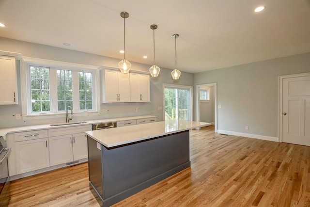 kitchen with white cabinetry, a sink, light wood-style floors, light countertops, and recessed lighting