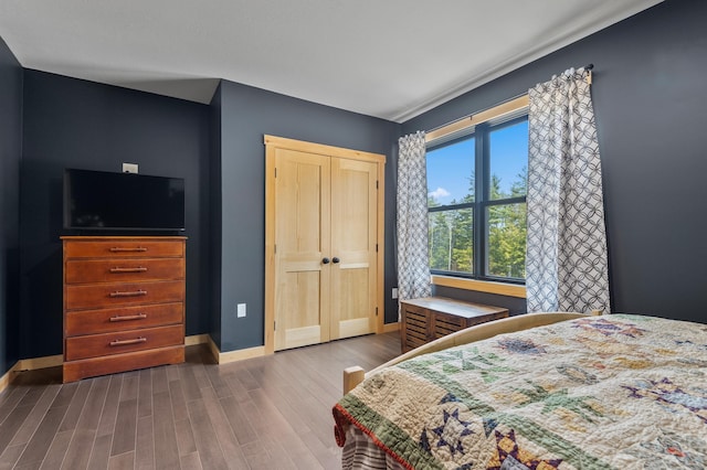 bedroom with dark wood-style flooring and baseboards