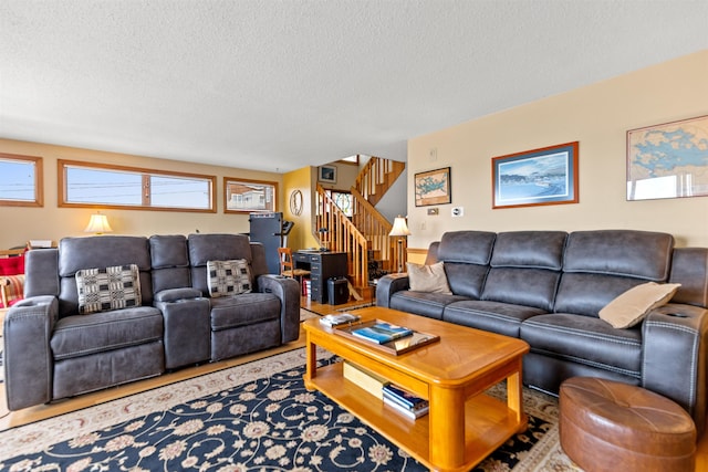 living area featuring stairs and a textured ceiling
