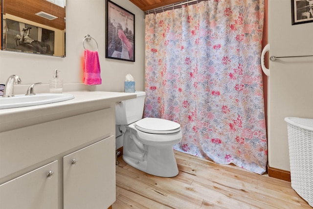 bathroom with wood finished floors, a shower with shower curtain, toilet, vanity, and visible vents