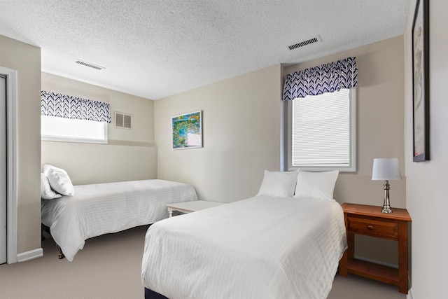 carpeted bedroom with a textured ceiling and visible vents