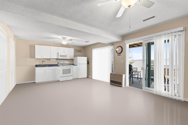 kitchen featuring a sink, dark countertops, ceiling fan, visible vents, and white appliances