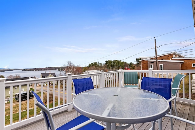 wooden deck with outdoor dining space and a water view