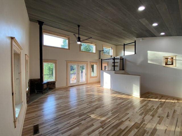 unfurnished living room with a wood stove, recessed lighting, wooden ceiling, a ceiling fan, and wood finished floors