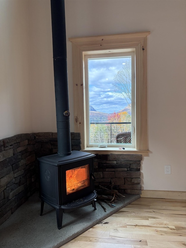 interior details with a wood stove and wood finished floors