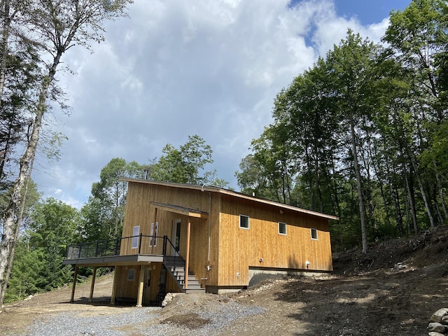 rear view of house featuring a wooden deck and stairs