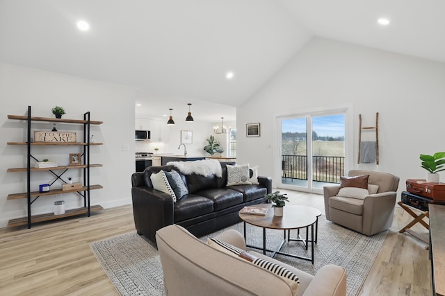 living room with high vaulted ceiling, light wood finished floors, and recessed lighting