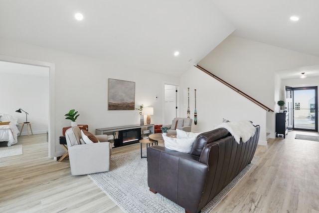 living room with recessed lighting, light wood-style floors, and vaulted ceiling