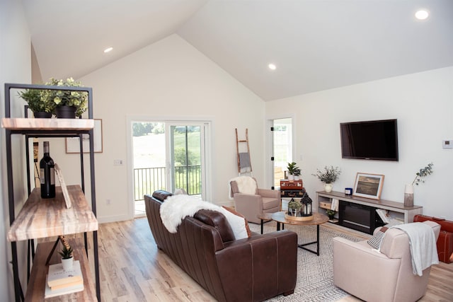 living room with light wood-style floors, recessed lighting, high vaulted ceiling, and baseboards