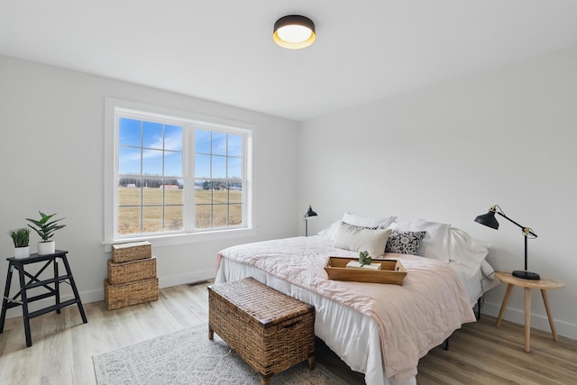 bedroom featuring baseboards, visible vents, and wood finished floors