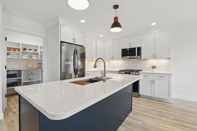 kitchen featuring stainless steel appliances, light wood-style floors, light countertops, and a sink
