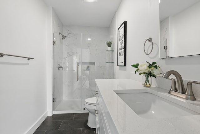full bath featuring tile patterned floors, toilet, vanity, baseboards, and a marble finish shower