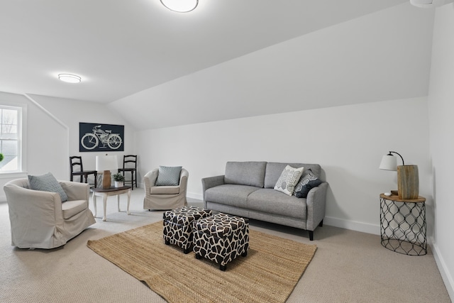 carpeted living room with baseboards and vaulted ceiling
