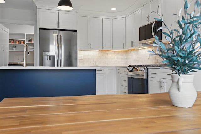 kitchen featuring a sink, wood counters, decorative backsplash, white cabinets, and appliances with stainless steel finishes