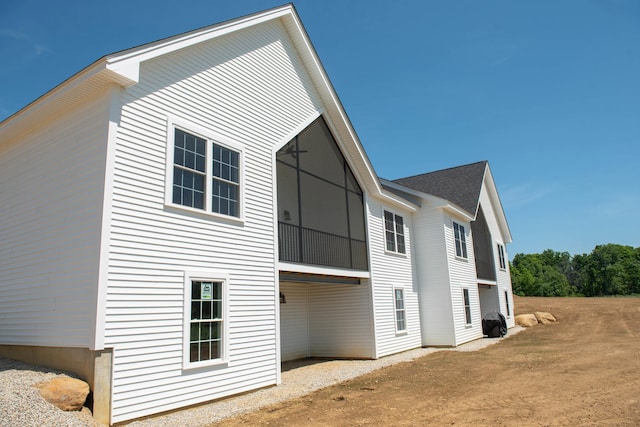 back of house featuring a shingled roof