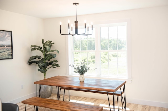 dining space featuring wood finished floors, a chandelier, and baseboards