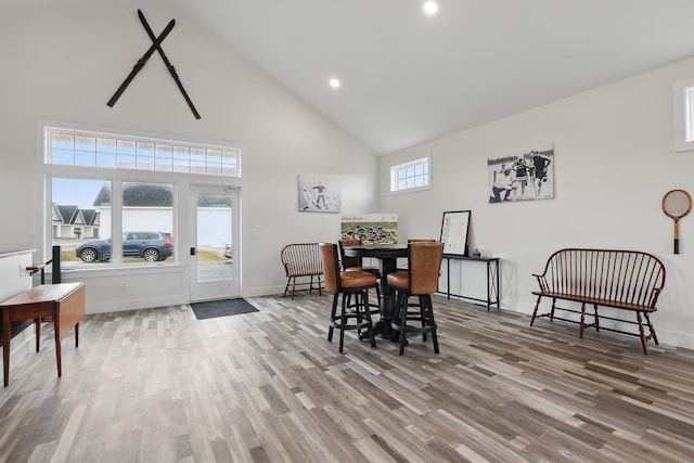 dining space with recessed lighting, high vaulted ceiling, wood finished floors, and baseboards