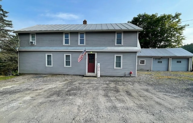 view of front of home with a chimney, a standing seam roof, and metal roof