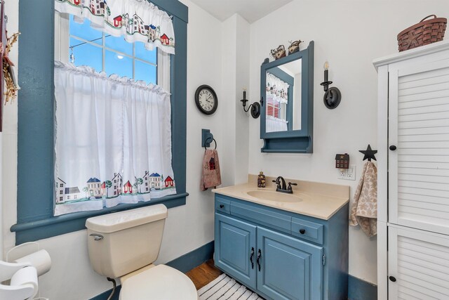 7449 School St, Loudon, NH 03307 - bathroom with wood finished floors, toilet, and vanity