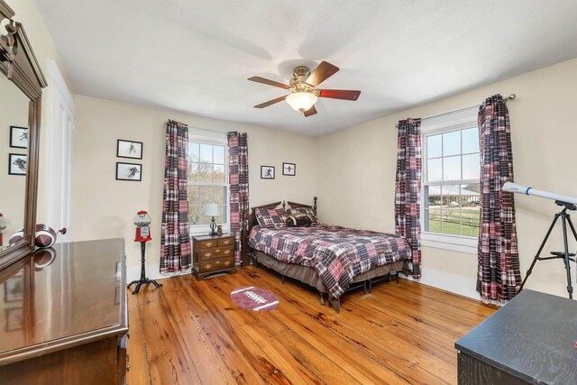 7449 School St, Loudon, NH 03307 - bedroom featuring light wood finished floors, a ceiling fan, multiple windows, and baseboards