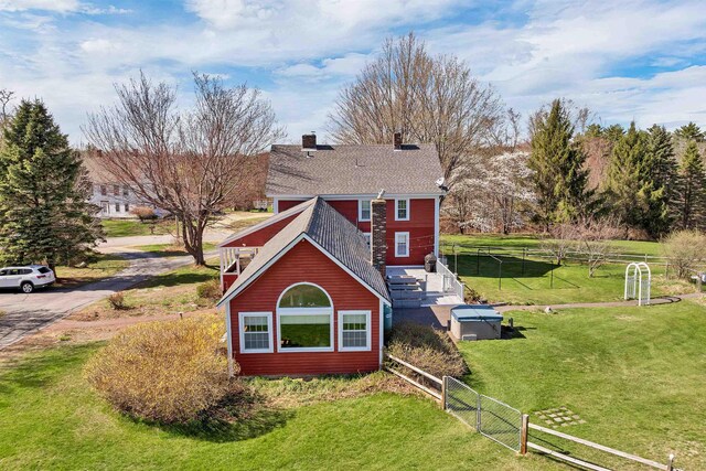 7449 School St, Loudon, NH 03307 - view of home's exterior featuring a chimney, fence, and a lawn