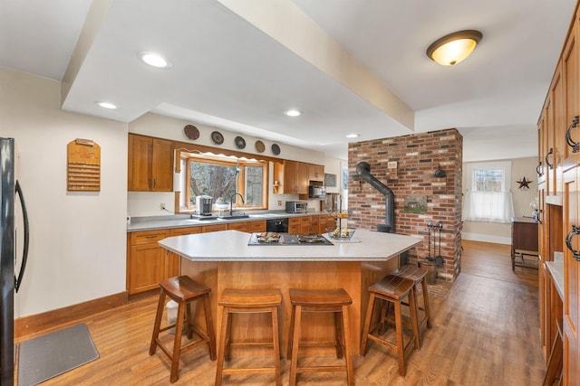 7449 School St, Loudon, NH 03307 - kitchen with a kitchen breakfast bar, light countertops, a kitchen island, baseboards, and wood finished floors