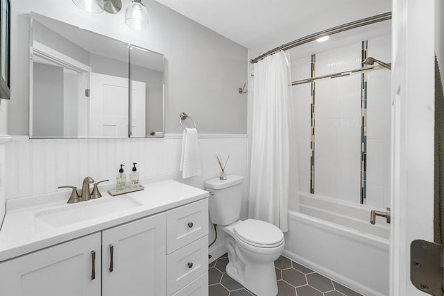 bathroom featuring shower / bath combo, vanity, tile patterned floors, toilet, and wainscoting
