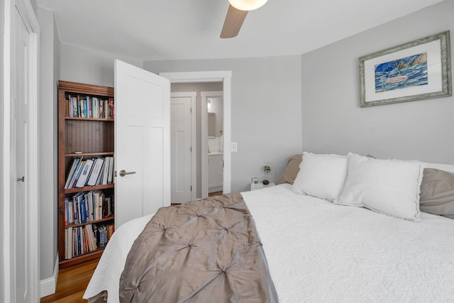 bedroom featuring a ceiling fan, wood finished floors, and connected bathroom