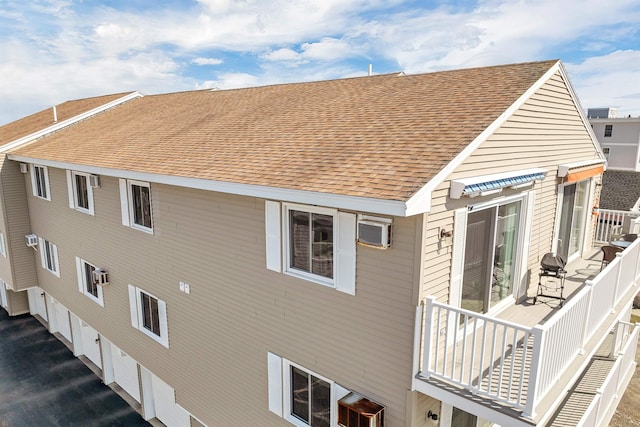 back of house with a shingled roof and an attached garage