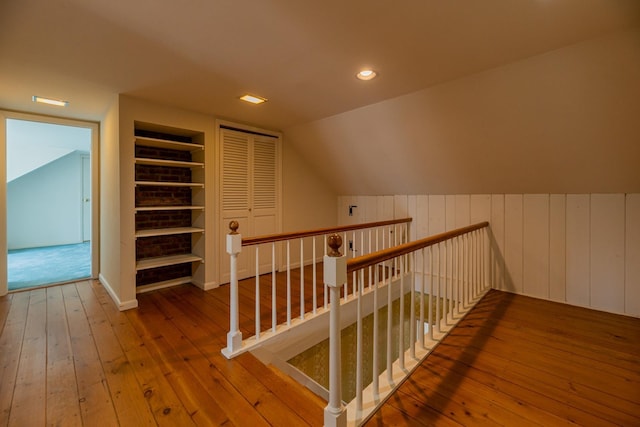 bonus room with recessed lighting, hardwood / wood-style floors, vaulted ceiling, built in shelves, and wooden walls
