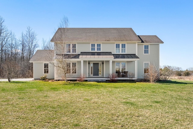 rear view of house with metal roof, a standing seam roof, a lawn, and covered porch