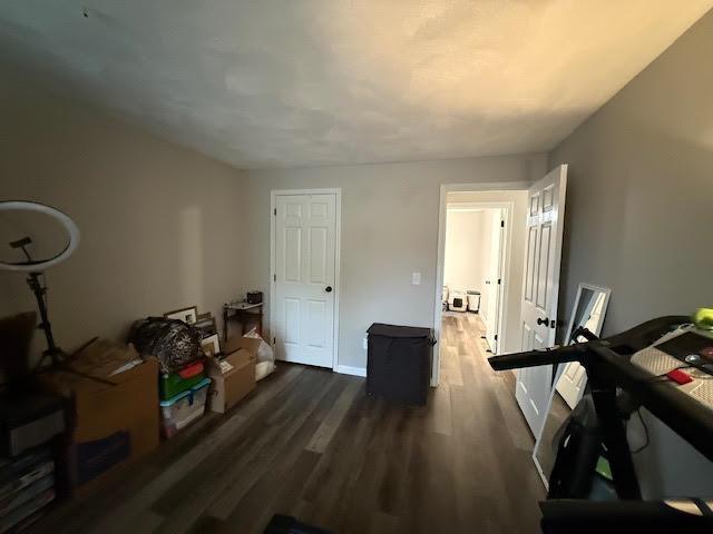interior space featuring dark wood-style flooring and baseboards