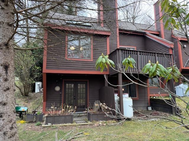 back of house featuring french doors, a wooden deck, and a chimney