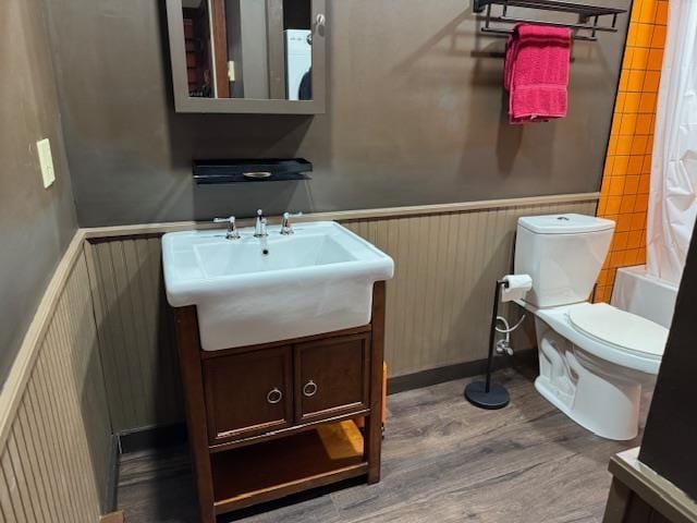 bathroom with vanity, wainscoting, wood finished floors, and toilet