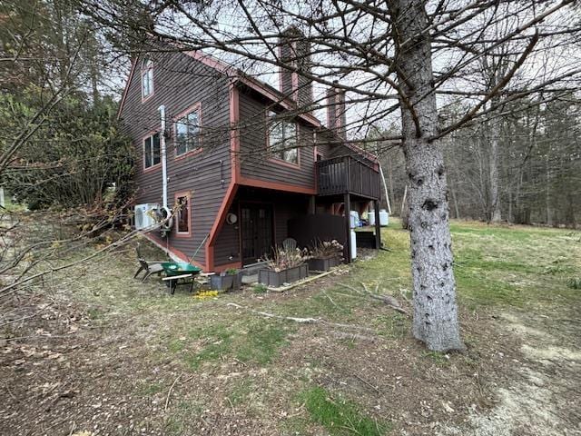 back of property featuring a wooden deck and a chimney
