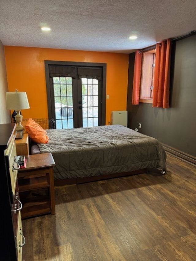 bedroom with french doors, a textured ceiling, access to outside, recessed lighting, and dark wood-type flooring
