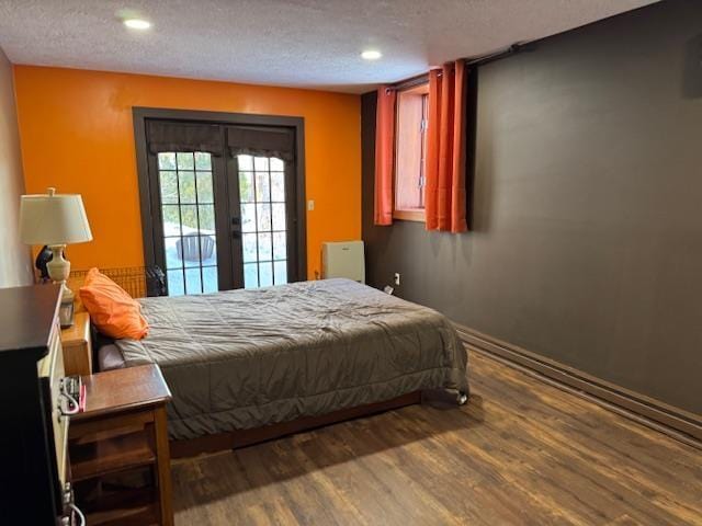 bedroom with a textured ceiling, access to exterior, french doors, and wood finished floors