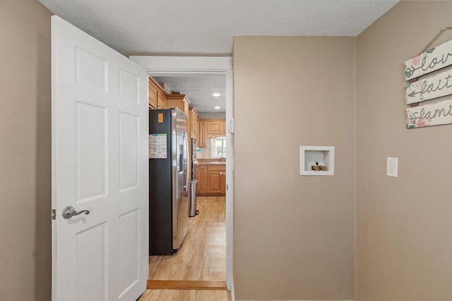 laundry area featuring a sink, hookup for a washing machine, recessed lighting, light wood finished floors, and laundry area