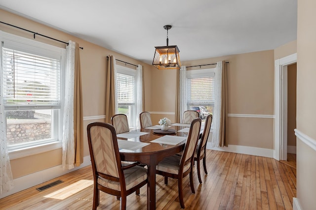 dining room with visible vents, a chandelier, plenty of natural light, and light wood-style flooring