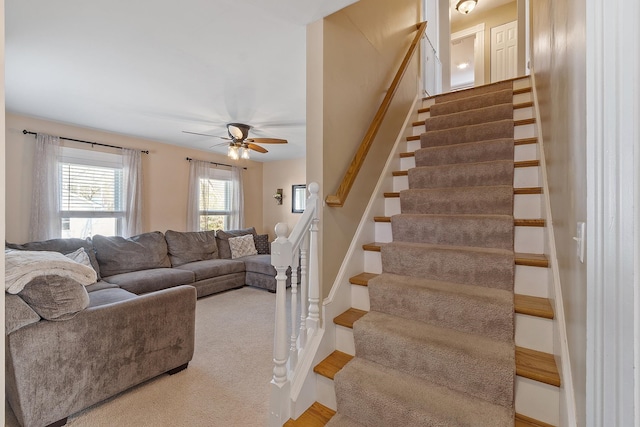 staircase featuring a ceiling fan