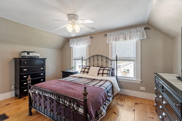 bedroom featuring lofted ceiling, light wood-type flooring, and baseboards