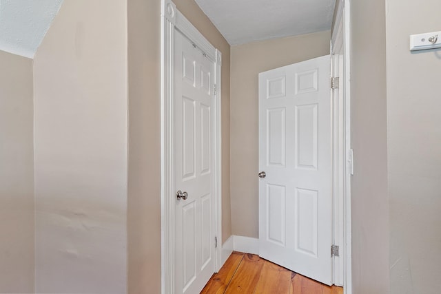 hall featuring light wood-style floors and baseboards