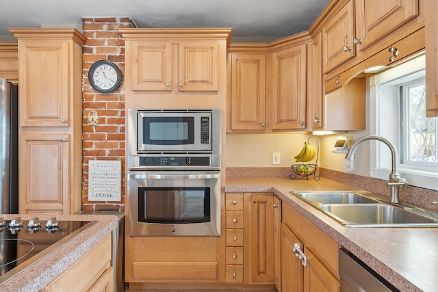 kitchen with appliances with stainless steel finishes, light brown cabinets, light countertops, and a sink