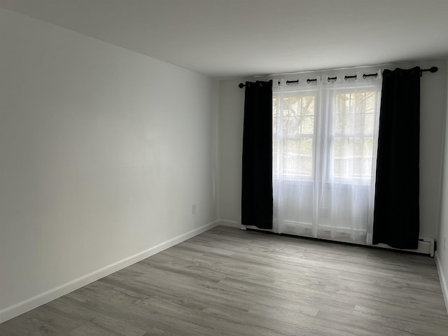 empty room featuring baseboards and wood finished floors