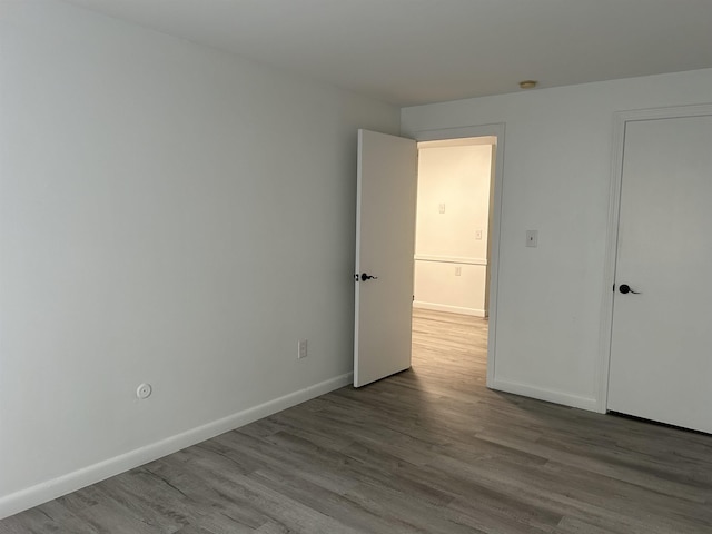 unfurnished room featuring wood finished floors and baseboards