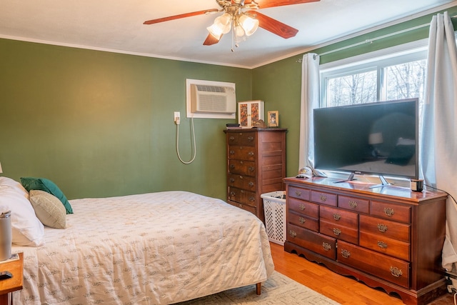 bedroom with a wall mounted air conditioner, a ceiling fan, and ornamental molding