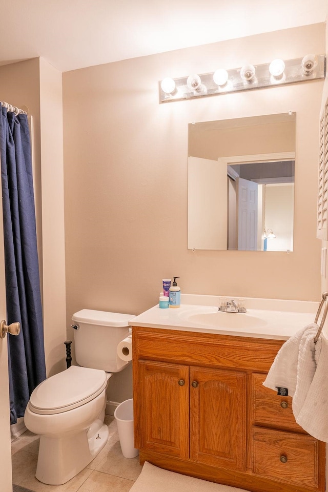 bathroom with toilet, vanity, and tile patterned floors